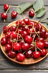 Fresh ripe cherries on black wooden table, closeup