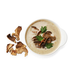 Tasty cream soup in bowl and dry chanterelle mushrooms isolated on white, top view