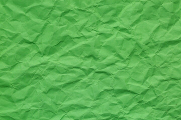Close-up of green crumpled paper texture,A close-up, top-down shot showcases the crinkled and uneven texture of green paper. Background concept.