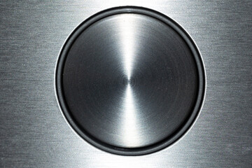 Close-up view of a circular metallic surface showcasing a smooth and polished texture. The light...
