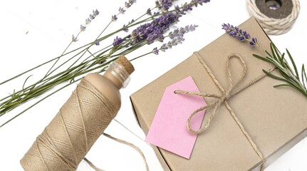 Gift wrapping with lavender twine and a pink tag on a white background
