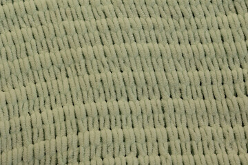 This detailed fabric texture displays a soft green color. The fine fibers create a woven pattern,...