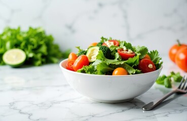 Fresh vegetable salad in a white bowl with cherry tomatoes, lettuce, and cucumber on a marble surface