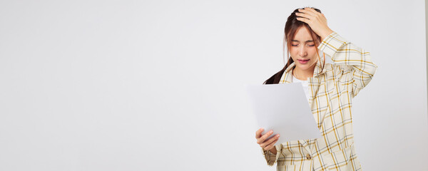 Surrounded by documents, the Asian woman looks drained by bill after bill. Financial pressure...