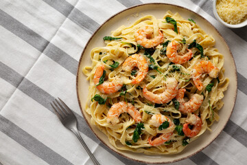 Homemade Creamy One-Pot Spinach Shrimp Pasta on a Plate, top view. Copy space.