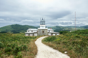 A path through the grass leads to the lighthouse at Cape Estaca de Bares