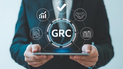 Businessman displays GRC governance, risk, and compliance diagram on a tablet, representing modern business management.