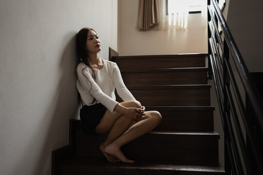 Depressed Asian woman sitting on stairs in house, Woman worry, Unhappy girl.