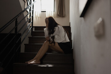 Depressed Asian woman sitting on stairs in house, Woman worry, Unhappy girl.