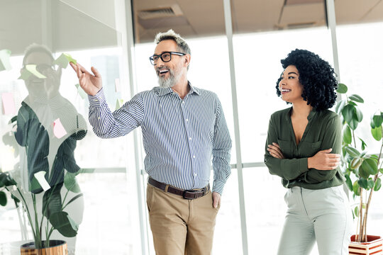 Professional coworkers discussing business strategies in a modern office environment with positive synergy and teamwork