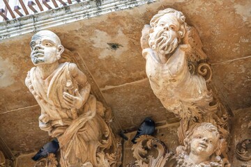 noto, italien - kleiner balkon mit pittoresken figuren