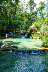 Naklejka premium Most magnificent and breathtaking nature of Kuang Si waterfall and cascade and its green, emerald crystal clear water and lake in Luang Prabang 