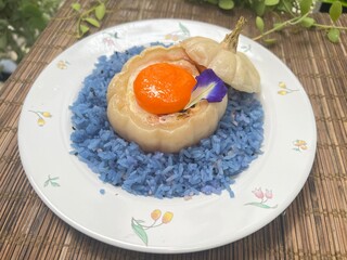 Mini pumpkin stuffed with steamed egg and egg yolk, served with blue rice.
