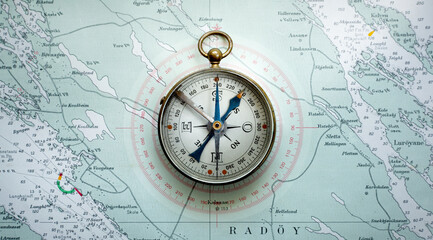 Magnetic old compass on old map. Travel, geography, history, navigation, tourism and exploration concept background. Retro compass on geography map.