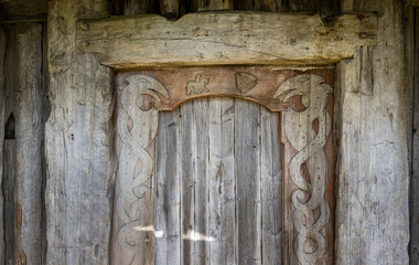 heavy wooden door with Norse motifs carved in at the viking village of Vestrahorn, Iceland