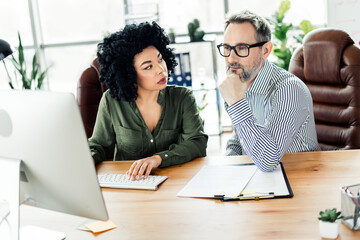 Diverse coworkers collaborating on project in modern office setting, teamwork and professionalism...