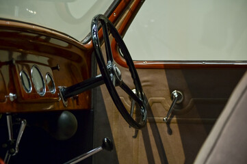 Detail of the interior of a vintage car. Retro car. Close-up of the old steering wheel, console, seats, insides of the  retro car. Interior of a classic vintage car