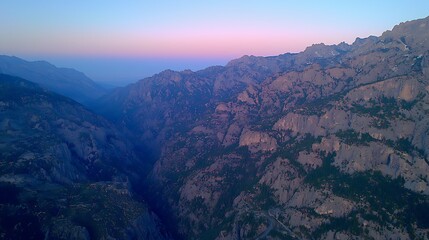 Fototapeta premium photo from drone camera, ultra-wide lens, layered ridgelines disappearing into soft pink and blue evening haze with smooth gradient sky