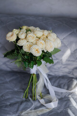 Elegant white rose bouquet on a soft fabric background in a bright indoor setting
