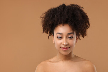Portrait of beautiful Brazilian woman after spa treatment on light brown background. Space for text