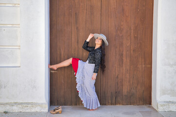Young woman, beautiful, brunette, flamenco dancer, wearing beautiful dress with jacket and hat,...