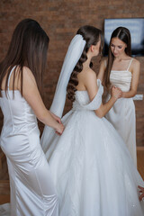 Naklejka premium Bridal preparation with friends in a cozy indoor setting prior to the wedding ceremony