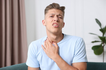 Portrait of sad man on sofa at home. Online medical consultation