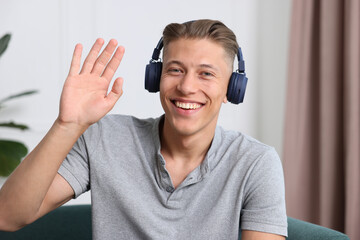 Man in headphones having online consultation with doctor at home