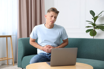 Sick man having online consultation with doctor via laptop at home