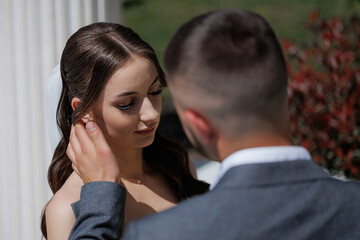Couple shares an intimate moment during an outdoor wedding ceremony in sunlight