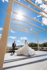 Couple celebrates wedding under bright sky at scenic outdoor venue