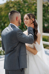 Couple sharing an intimate moment during their outdoor wedding ceremony in a lush garden setting