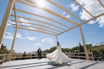Couple celebrates wedding on sunny terrace with beautiful blue sky backdrop