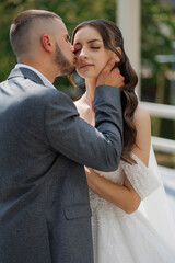 Couple shares a romantic moment during outdoor wedding ceremony in lush garden setting