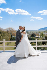 Couple shares romantic moment at outdoor wedding with scenic backdrop near mountains