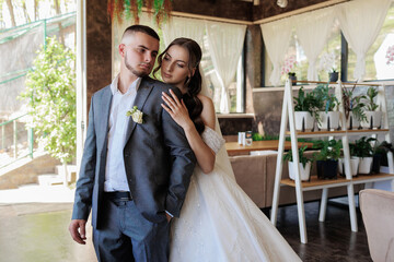Elegant couple embraces in modern venue during intimate wedding ceremony