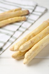 Raw asparagus spears on white wooden table, closeup
