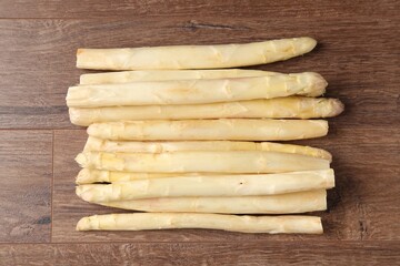 Raw white asparagus spears on wooden table, top view