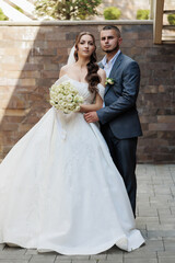 Couple poses for a romantic wedding portrait in an elegant outdoor setting