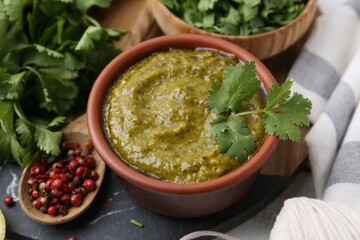 Tasty sauce with cilantro and other ingredients on table, closeup