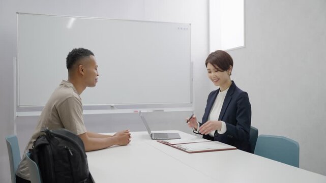 手続きをする外国人労働者とスタッフ