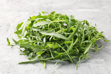 Fresh ripe green arugula leaves on grey table, closeup