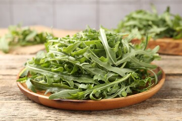 Fresh ripe green arugula leaves on wooden table, closeup