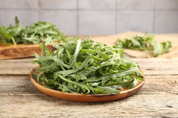Fresh ripe green arugula leaves on wooden table, closeup