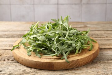 Fresh ripe green arugula leaves on wooden table, closeup