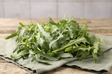 Fresh ripe green arugula leaves on wooden table, closeup
