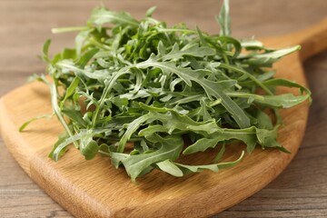 Fresh ripe green arugula leaves on wooden table, closeup