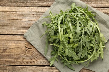 Fresh ripe green arugula leaves on wooden table, top view. Space for text