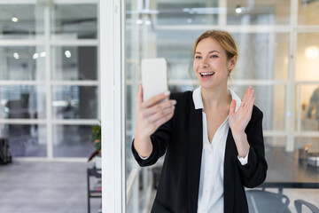 Blonde pretty business woman having a video call and smiling