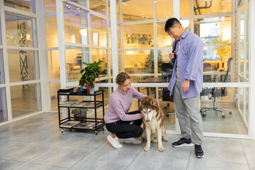 Two colleagues in a coworking area with a dog